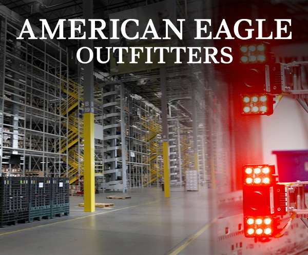 O logotipo da American Eagle é exibido ao lado de prateleiras de armazenamento automatizadas no armazém, com um sistema de visão Cognex montado.